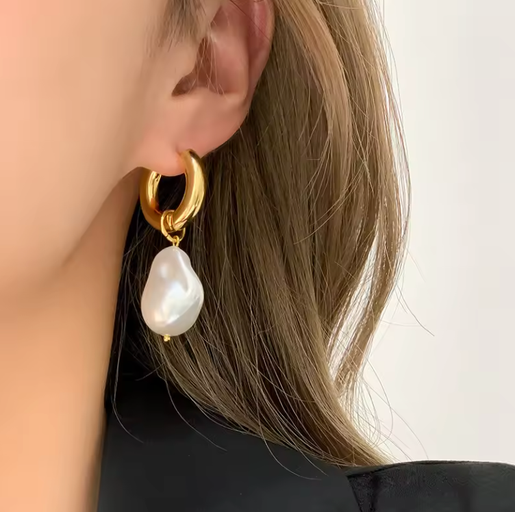 Stainless steel PVD plated pearl drop earrings on model.